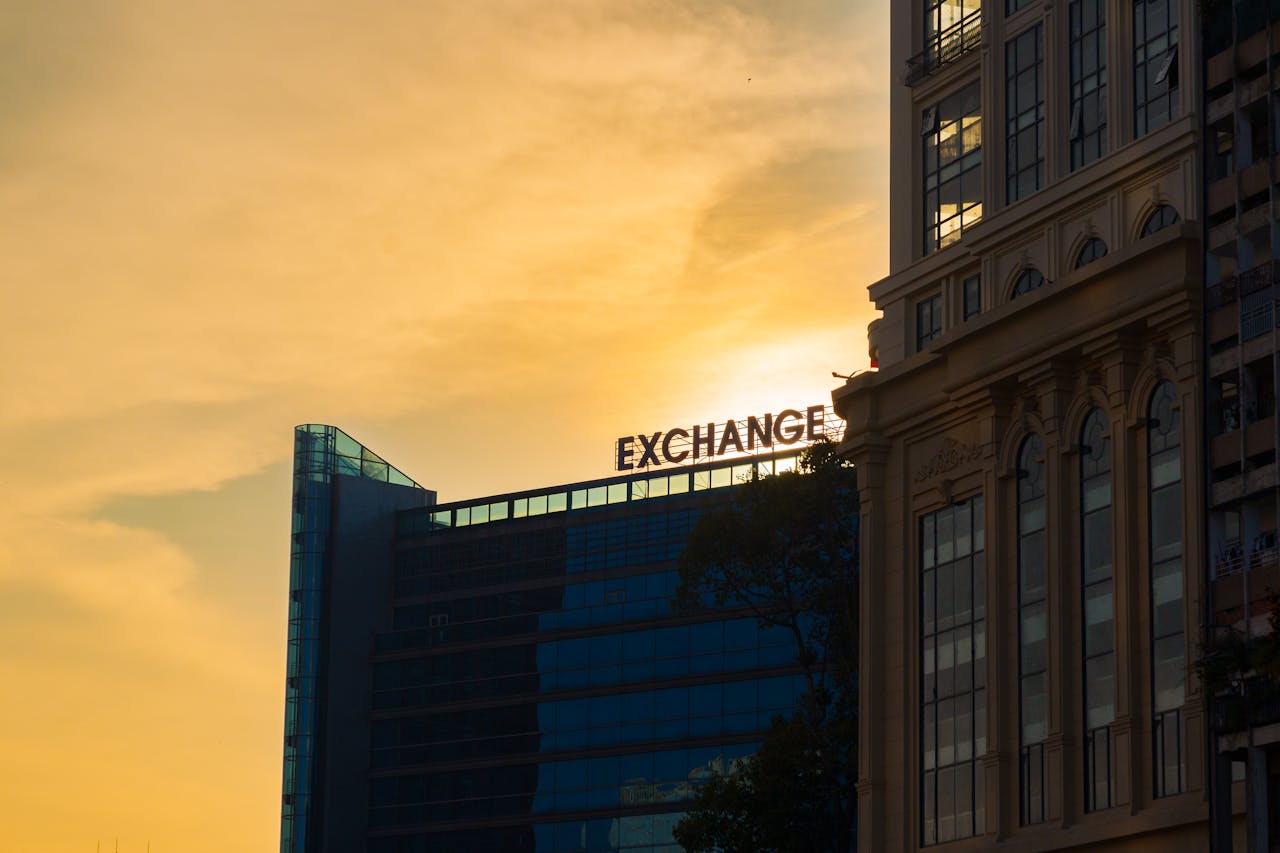 Silhouette of modern office building with EXCHANGE sign during sunset.