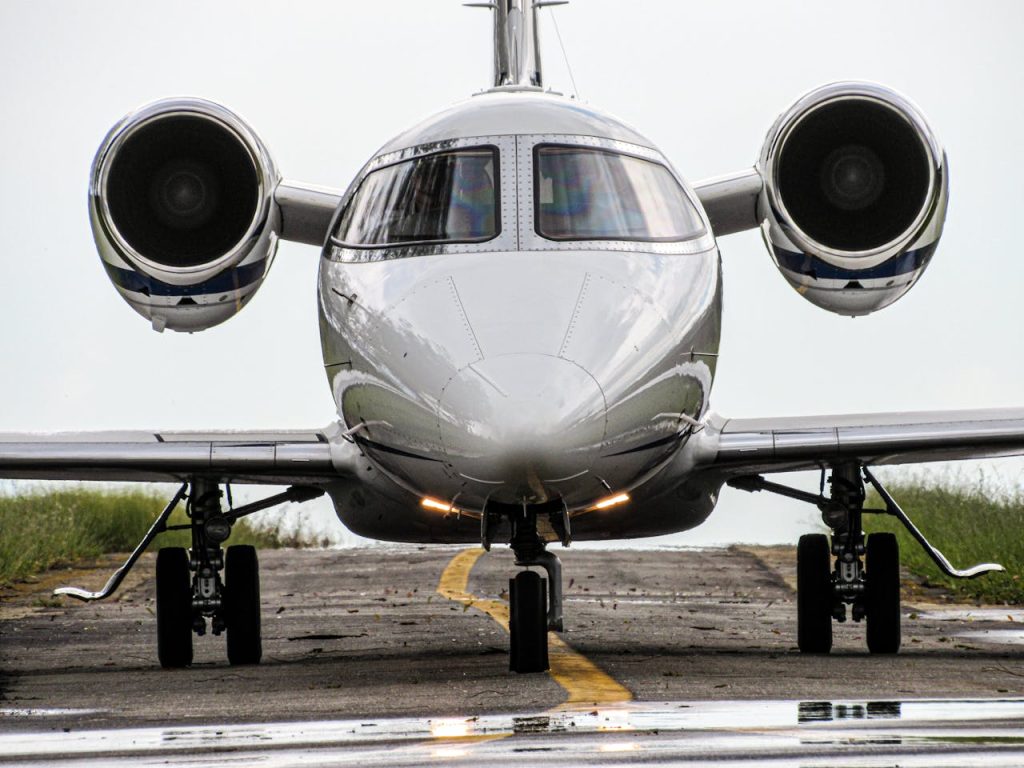 Front view of a sleek jet aircraft on a runway, ready for takeoff in daylight.
